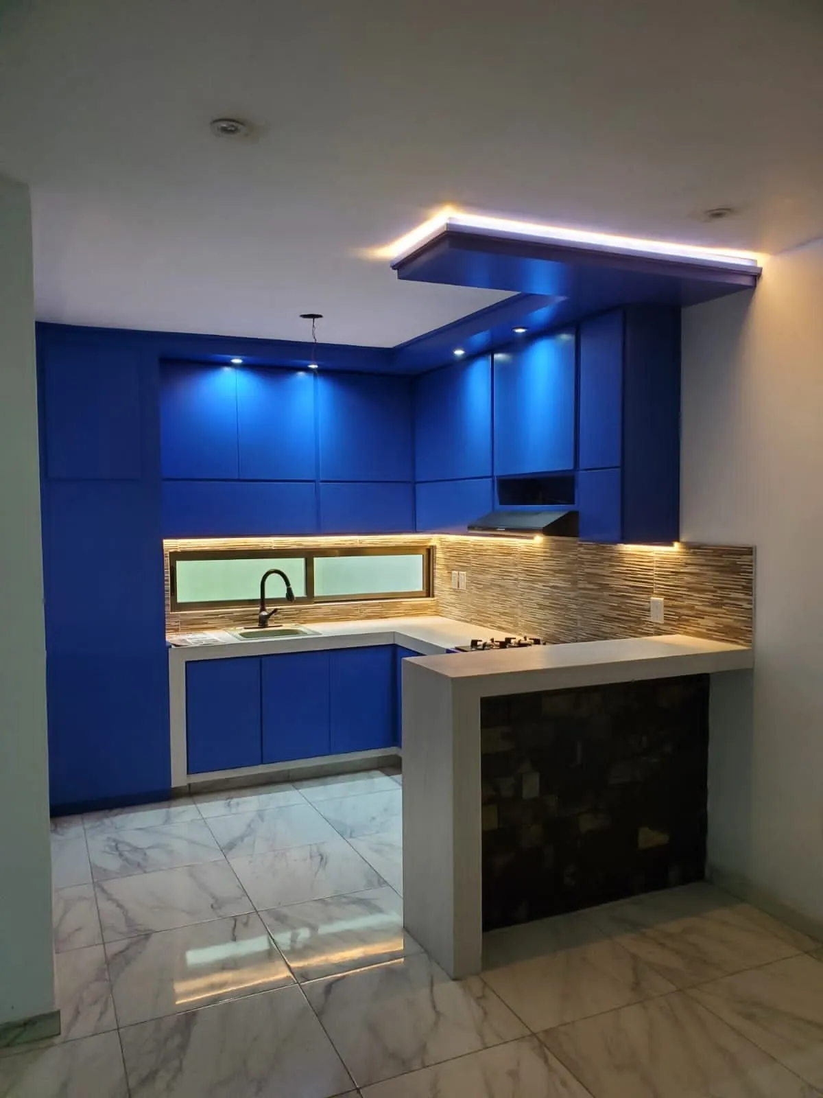 Cocina azul con plafón iluminado