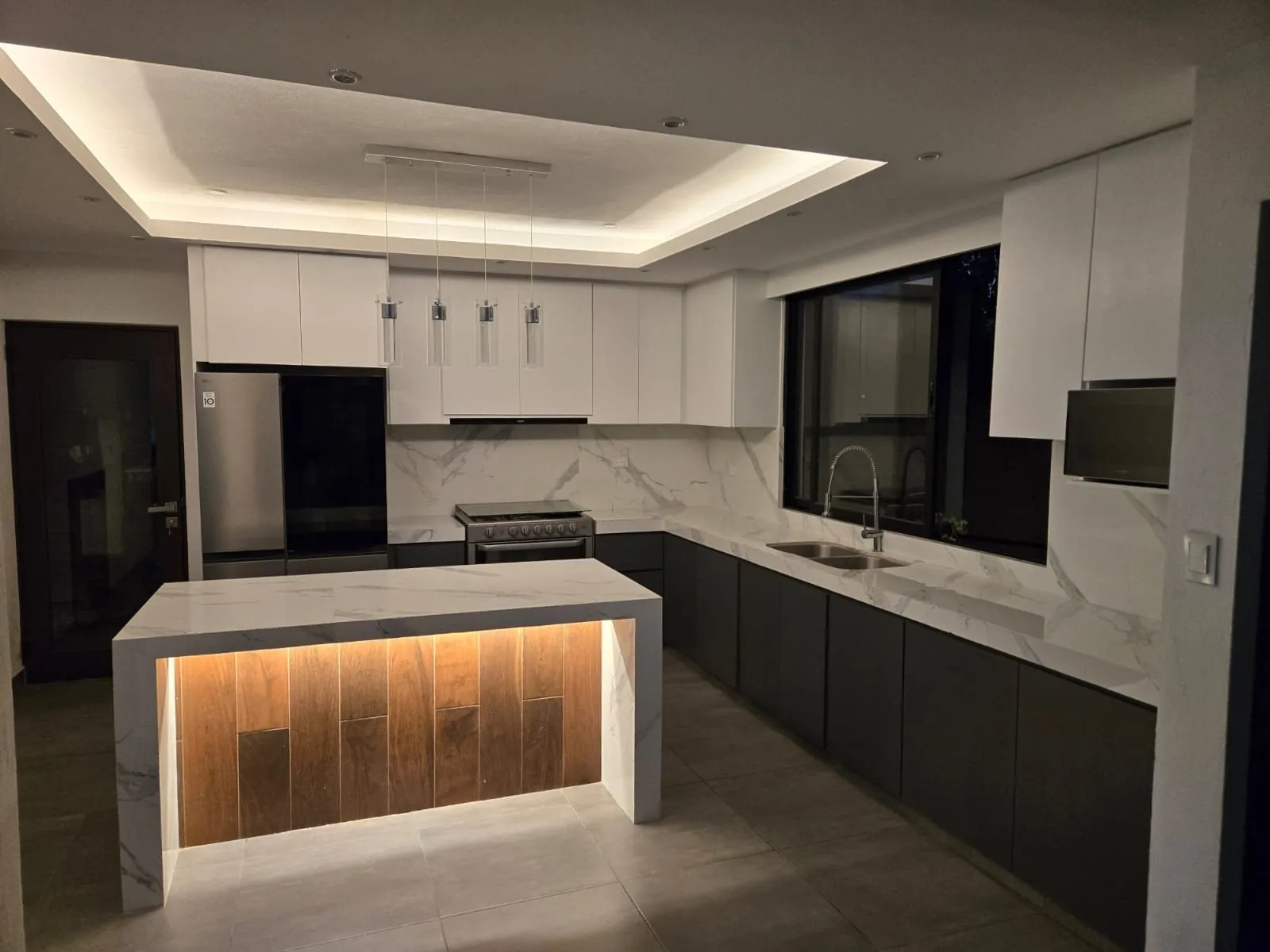 Cocina con isla tipo mármol y luz LED