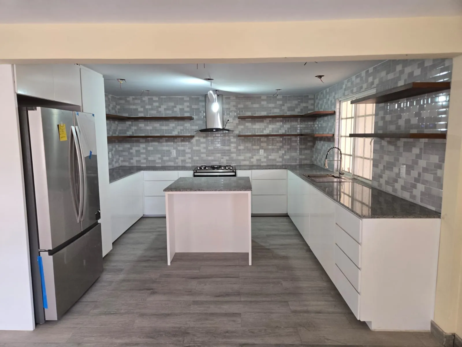 Cocina blanca con isla y repisas flotantes