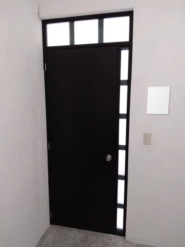 Foto de una puerta con una hoja tamaño carta pegada en la pared y las medidas marcadas